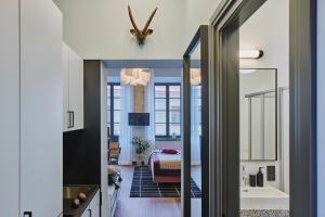 维尔纽斯ROOMA Apartments的走廊设有带浴缸的浴室和一间卧室