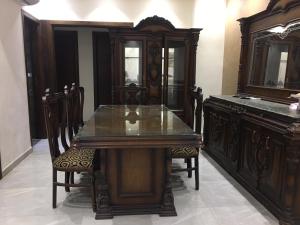 开罗Ramco For Furnished Apartments And Accommodation Compound Leila的一间带木桌和椅子的用餐室