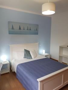 丰沙尔FX Pena的一间卧室配有一张带蓝色被子和帆船的床。
