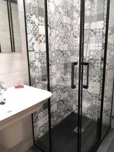塞哥维亚胡安布拉沃旅馆的带淋浴和白色盥洗盆的浴室