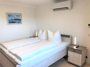 巴特Speicher Residenz Barth E4 App 9的一间卧室配有带白色床单和枕头的床。