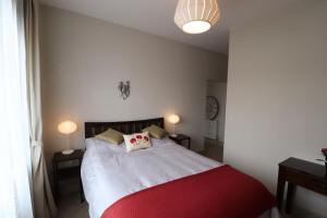 伦敦Stylish light-filled 1 Bedroom Flat In Hammersmith的卧室配有红色和白色的床及两盏灯