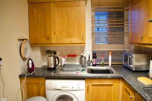 爱丁堡Newly Refurbed Home with Free Parking的厨房配有洗衣机和水槽