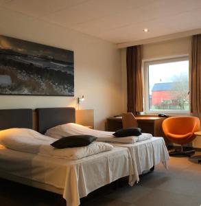 厄什塔Havila Hotel Ivar Aasen的酒店客房设有两张床和窗户。