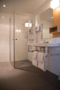 厄什塔Havila Hotel Ivar Aasen的带淋浴、盥洗盆和镜子的浴室