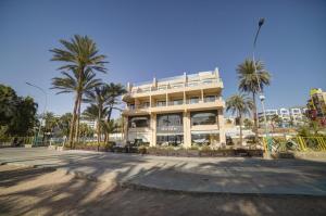 亚喀巴Sea view hotel的一座白色的大建筑,前面有棕榈树
