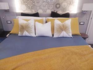 韦尔纳扎Vernazza Luxury Apartment的一间卧室配有黄色和白色枕头的床