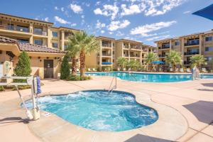 圣乔治WorldMark Estancia的棕榈树游泳池和公寓楼