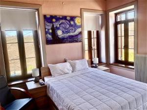 DolianáHelios - Epirus Traditional guesthouse的卧室配有一张床,墙上挂有绘画作品