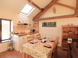 WigtonHorseshoe Cottage的厨房以及带桌椅的用餐室。