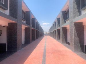 圣胡安德里奥Motel Pedregal Suites的一条有红砖人行道的建筑的空走廊