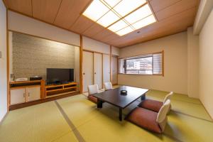 黑部市Kurobe Unazukionsen Yamanoha的客厅配有桌子和电视