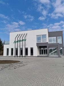 Sępólno KrajeńskieHotel ANTARES的一座白色的大建筑,上面有标志