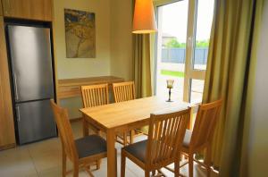 帕兰加Smėlio Vila Apartments的厨房配有木桌、椅子和冰箱