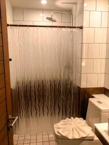洛坤府Navakitel Design Hotel的设有带卫生间的浴室内的淋浴帘