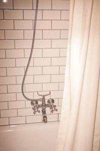 雷克雅未克客可思旅舍的浴室设有淋浴帘,毗邻白色砖墙