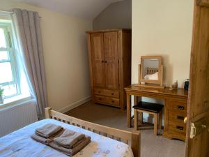 康威River Cottage的一间卧室配有一张床、梳妆台和镜子
