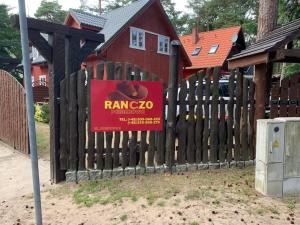 波别罗沃Ranczo Pobierowo的房屋前木栅栏上的标志