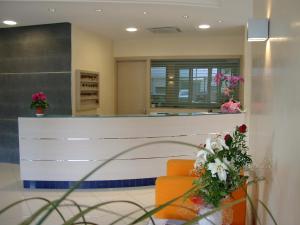 利尼亚诺萨比亚多罗博洛尼亚酒店的大堂设有橙色椅子和鲜花柜台
