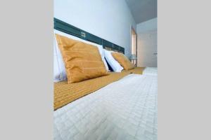 费德拉帕加内拉Appartamento Dolomella的卧室配有带金色枕头的大型白色床