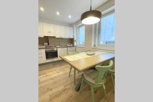 费德拉帕加内拉Appartamento Dolomella的厨房配有木桌和绿色椅子