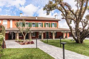 拉蒂萨纳Hotel Residence - Il Giardino del Cigno的一座橘色房子,前面有一棵树