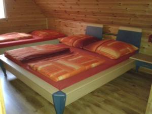波别罗沃Ranczo Pobierowo的带木墙的客房内的三张床