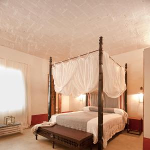 法维尼亚纳La Casa Dell'Arancio的卧室配有带白色窗帘的天蓬床