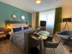 伯格奥夫费马恩Hafen Hotel Schützenhof的酒店客房配有一张床、一张桌子和一把椅子。