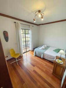 洛斯雷亚莱霍斯Canary Bio Hostel Tenerife的一间卧室配有一张床、一张桌子和一把椅子