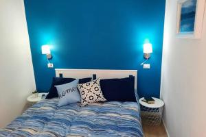 维博瓦伦蒂亚Meli's House的蓝色卧室配有带枕头的床