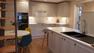 福丁布里奇Riverside Lodge Pied a Terre的厨房配有白色橱柜和桌椅