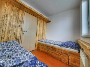 穆捷尼采Apartmán Marie的一间卧室设有两张床和一张木凳