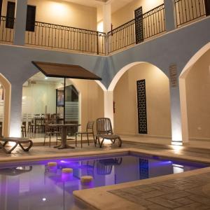 梅里达Hotel Las Monjas的一座带桌椅的别墅内的游泳池