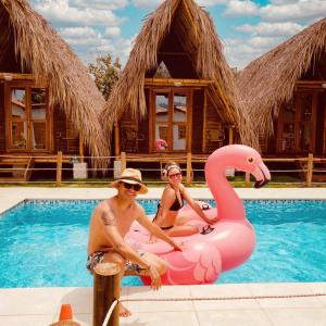 帕洛米诺Palomino Sunrise的两人坐在游泳池里,坐在粉红色的火烈鸟