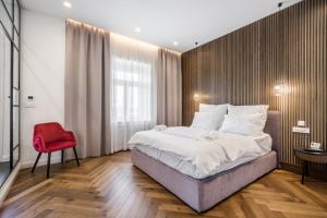 布达佩斯Budapest Eye- Boutique Suites, by BQA的一间卧室配有一张大床和一张红色椅子