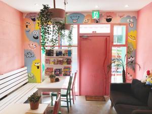 大阪雅多玛鲁旅馆的一间带桌子和粉红色墙壁的用餐室