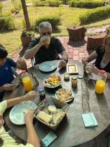 圣拉斐尔Finca La Penúltima-Posada的一群坐在桌子旁吃食物的人
