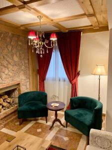 阿拉霍瓦科斯诺纳斯艾里斯奥尼旅馆的客厅配有两把绿色椅子和壁炉
