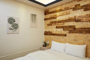 台南府城商旅文创新馆的一间卧室设有木墙和一张床