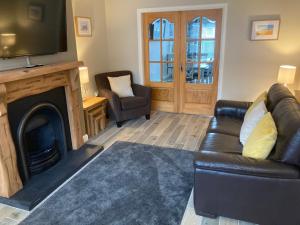 波特拉什Hopefield Premium Holiday Home Portrush Sleeps 10 4 bedrooms的客厅配有沙发和带电视的壁炉。