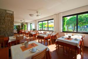 利多迪卡马约雷维西利亚住宿加早餐旅馆的餐厅设有桌椅和大窗户。