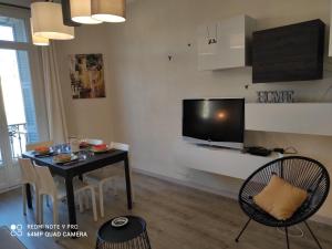 尼斯Pretty and quiet top floor 2 bedroom flat in the port area of Nice的客厅配有桌子和墙上的电视