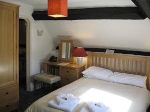 Bredwardine红狮宾馆的一间卧室配有带毛巾的床