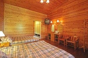 Hualing拉拉山达观农场的小木屋卧室配有两张床和电视