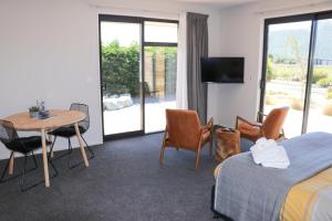 特卡波湖Fivestone Suite的酒店客房带一张床、一张桌子和椅子