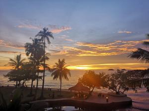 象岛象岛白兰海滩度假酒店的棕榈树海滩上的日落和海洋
