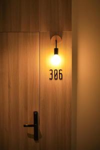 帕夭M2 Hotel Waterside的木门上的灯,有号码