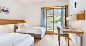 菲斯普毕东思豪斯圣乔德酒店的酒店客房设有两张床、一张书桌和一个窗户。