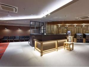 东京涩谷东急REI酒店的一间设有理发店的等候室,配有长凳和椅子